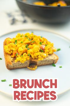 a white plate topped with two pieces of bread covered in scrambled eggs