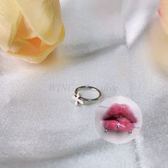 a ring with a cross on it sitting next to a flower and a white cloth