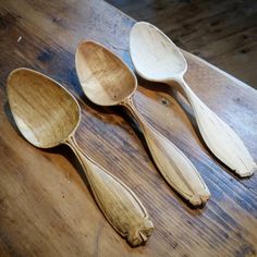 three wooden spoons sitting on top of a wooden table