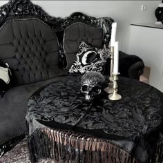 a living room with black furniture and a skull head on the table