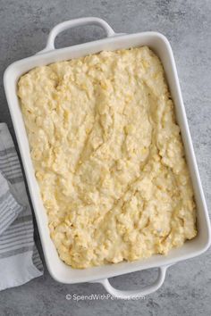 a white casserole dish filled with mashed potatoes on a gray counter top