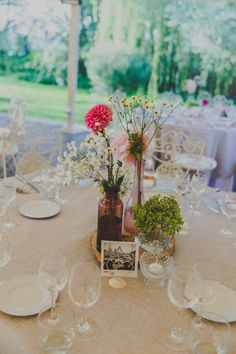 the table is set with plates and flowers in vases on top of each other