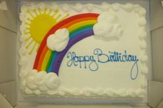 a birthday cake with white frosting and rainbow design