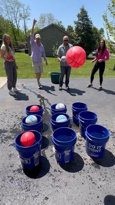 several people are playing with buckets and balls