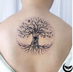 a woman's back with a tree tattoo on her left shoulder and stars around it