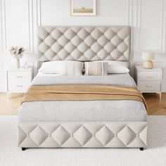 a bedroom with a bed, nightstands and pictures on the wall above it in white colors