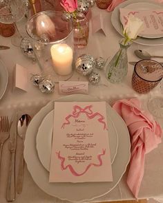 the table is set with silverware, pink napkins, and white dinner plates