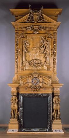 an ornate wooden fireplace with carvings on the front and sides, along with a clock