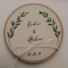 a hand embroidered wedding ornament with the names and date written in cursive writing