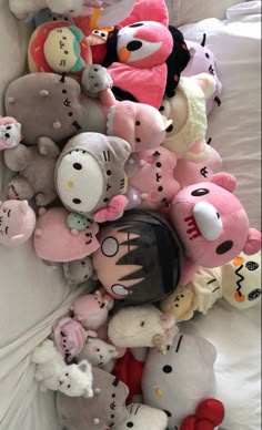 a pile of stuffed animals sitting on top of a bed