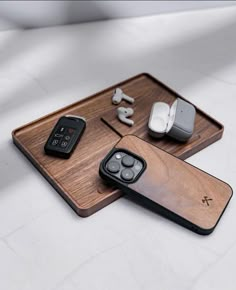 two wooden trays with cell phones and earbuds on them