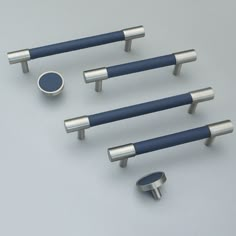 four metal handles and two knobs on a gray surface