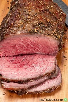 sliced meat sitting on top of a cutting board next to a knife