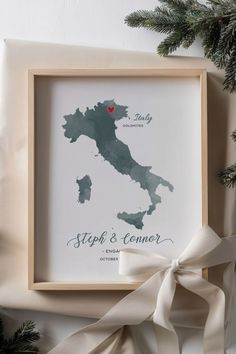 a framed map with the location of italy on it and a ribbon tied around it