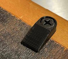 a black object sitting on the ground next to a wooden flooring board and door