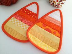 two triangle shaped bibs sitting on top of a table