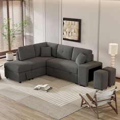 a living room with a gray sectional couch and chair in it's center area