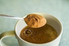 a spoon full of cinnamon spice in a white cup