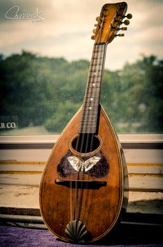 an old ukulele sitting on top of a window sill