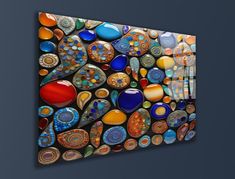 an abstract painting on the wall with many different colors and shapes, including glass beads