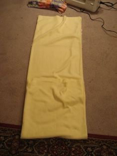 a pair of scissors and yellow cloth on the floor next to a cordless phone