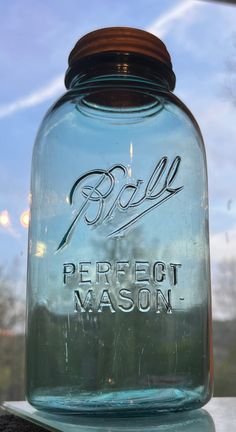 a blue mason jar sitting on top of a window sill with writing on it