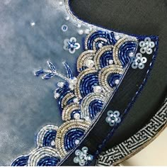 a blue and black hat with beading on it