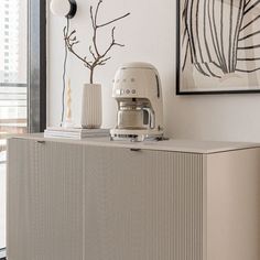 a kitchen mixer sitting on top of a white cabinet