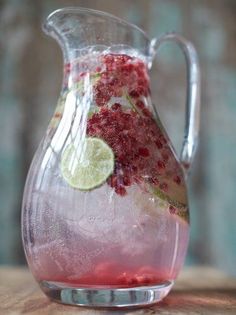 a pitcher filled with liquid sitting on top of a wooden table