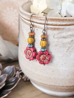 Add a touch of boho charm to your jewelry collection with these Red Rustic Czech Glass Flower Earrings. They feature colorful red Czech flowers that bring a botanical and earthy feel to any outfit. Perfect for those looking to make a statement with a unique and rustic accessory. Czech glass beads Antique brass accents Antique bronze ear hooks Drop 1.75" Created in studio - Wilmington, NC Cheap Czech Glass Necklaces With Polished Beads, Czech Beads Jewelry, Glass Flower Earrings, Rustic Accessories, Czech Glass Jewelry, Diy Jewelry Gifts, Bead Projects, Wilmington Nc, Brass Accents