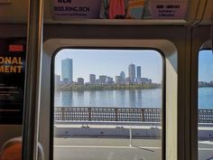 the view from inside a bus looking out at a river and cityscape in the distance