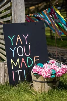 a sign that says yay you made it next to some flowers in a bucket