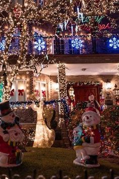 christmas lights decorate the front yard of a house with snowmen and other holiday decorations