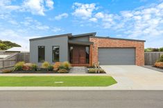 a house with a driveway in front of it and grass on the ground next to it