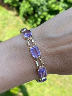 "This exquisite bracelet holds approx 26.10ctw of genuine emerald cut purple amethyst. (9 stones) It weighs 13.8g and is stamped 14k yellow gold.  It measures 7.5\" in length" Luxury Fine Jewelry Purple Bracelets, Gold And Purple Bracelet, Luxury Purple Rectangular Jewelry, Lavender Emerald Cut Jewelry For Formal Occasions, Formal Purple Fine Jewelry Bracelet, Purple Rectangular Jewelry For Formal Occasions, Formal Rectangular Purple Jewelry, Formal Purple Rectangular Jewelry, Purple And Gold Jewelry