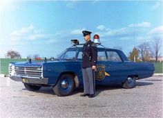 a police officer standing in front of a blue car