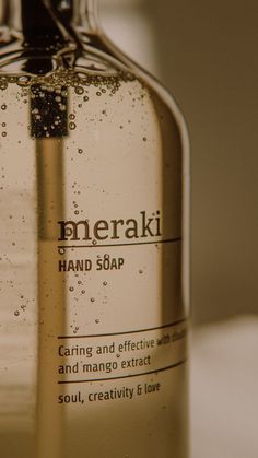 a close up of a bottle of hand soap on a table with water droplets around it