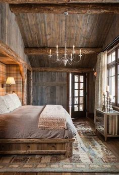 a bedroom with wooden walls and ceilinging has a chandelier