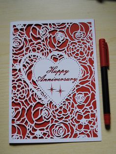 a valentine's day card with a heart cut out on it and a pen next to it