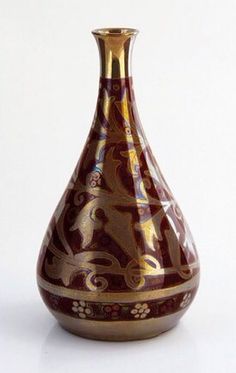 a brown and gold vase sitting on top of a white table