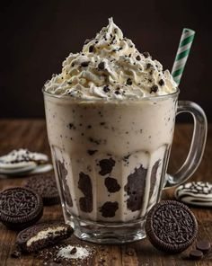 an ice cream sundae in a glass with cookies around it on a wooden table