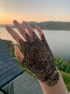 a person's hand with a finger print on it and water in the background