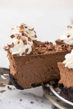 a piece of chocolate pie on a plate with whipped cream and chocolate shavings