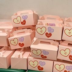 many pink boxes with hearts are stacked on top of each other