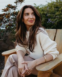 a woman sitting on top of a wooden bench