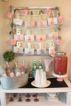 a table topped with bottles and cups filled with drinks next to a sign that says happy birthday