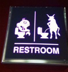 a restroom sign is lit up in the dark