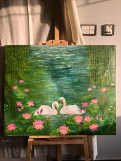 an easel with a painting on it and a swan in the water