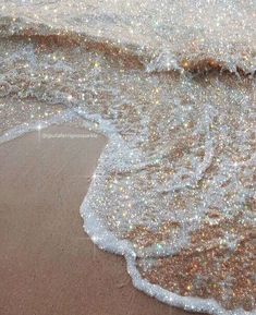 an ocean beach with sparkling sand and water