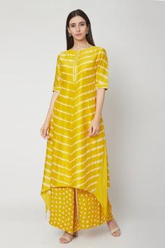 Sunshine yellow high-low kurta with all-over leheriya print. Paired with bandhej print palazzo pants.
Component: 2
Printed
Neckline: Round
Sleeve Length: Half
Fabric: Modal Satin
Color: Yellow
Asymmetric hem
Detailing at neck and sleeves
Long kurta - Aza Fashions Haldi Outfits For Women, Lehriya Kurti Designs, Bandhni Kurti Designs Latest, Lehariya Kurti Designs, Satin Kurti Designs, Trendy Ethnic Outfits, Haldi Dresses, Haldi Wedding, Printed Kurti Designs